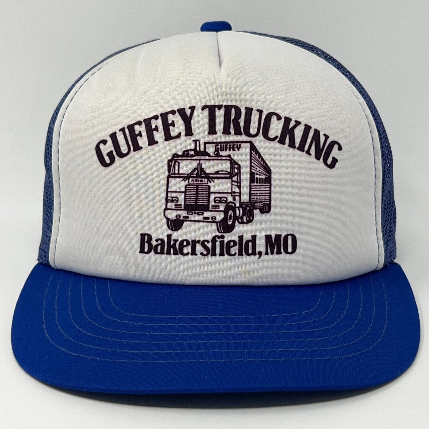 Blue and white trucker hat with Guffey Trucking logo and Missouri detail