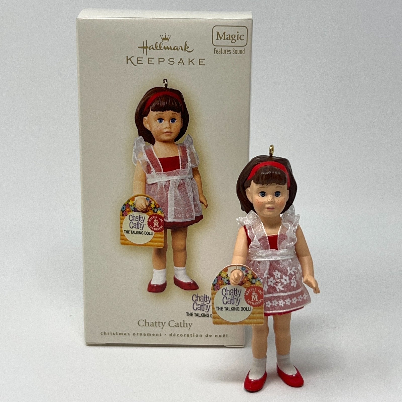 Hallmark Keepsake Chatty Cathy ornament in white dress with red accents, front view, featuring sound functionality