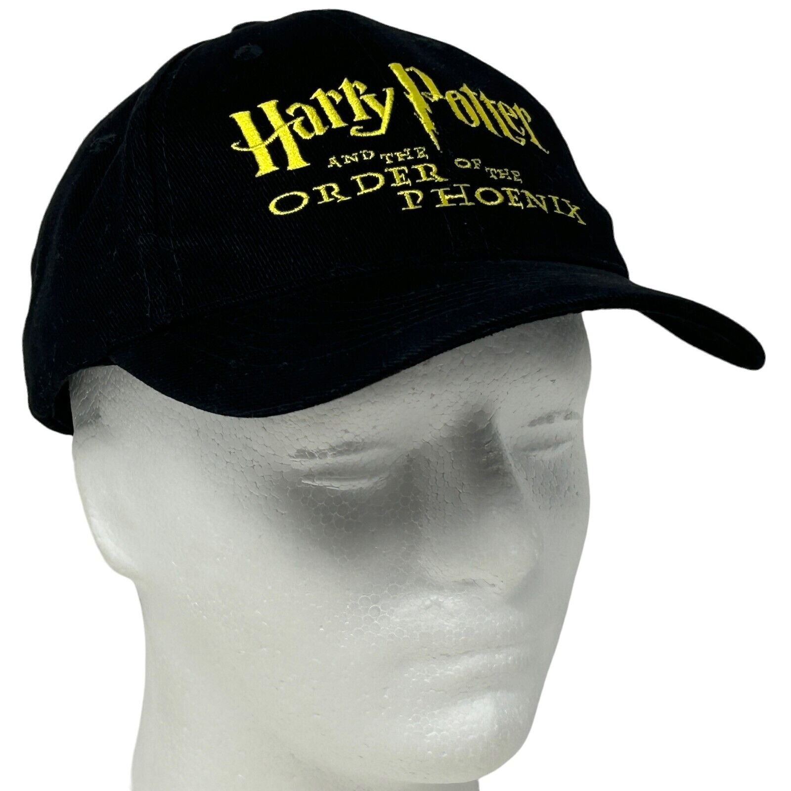 Black Harry Potter cap featuring logo text from Order of the Phoenix, side view on mannequin head