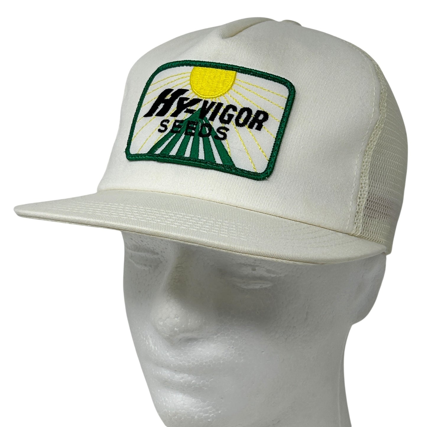 White farmer hat with green and yellow HYVIGOR SEEDS logo on the front, featuring a curved brim