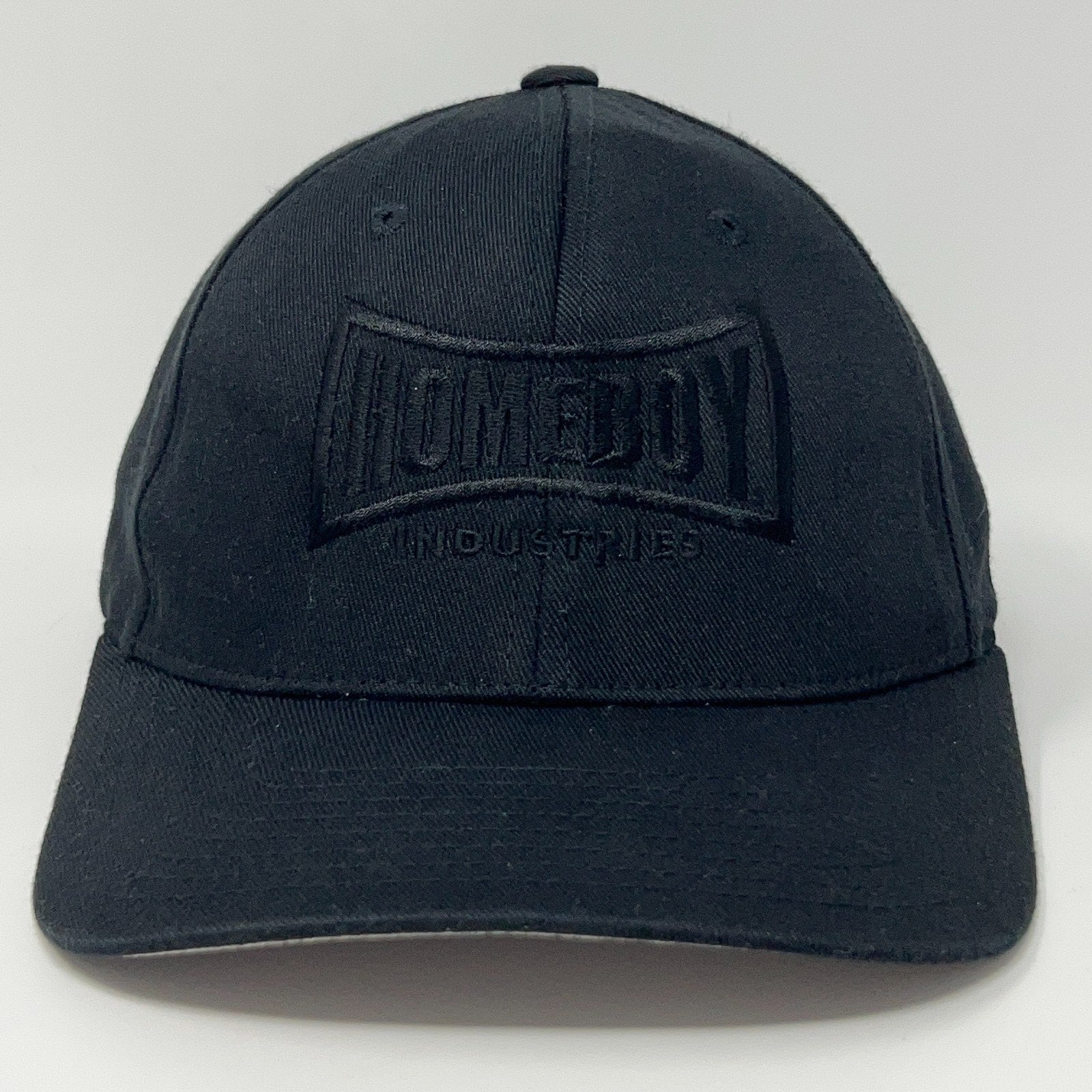 Black Flexfit cap featuring Homeboy Industries logo in front view, adjustable size for comfort