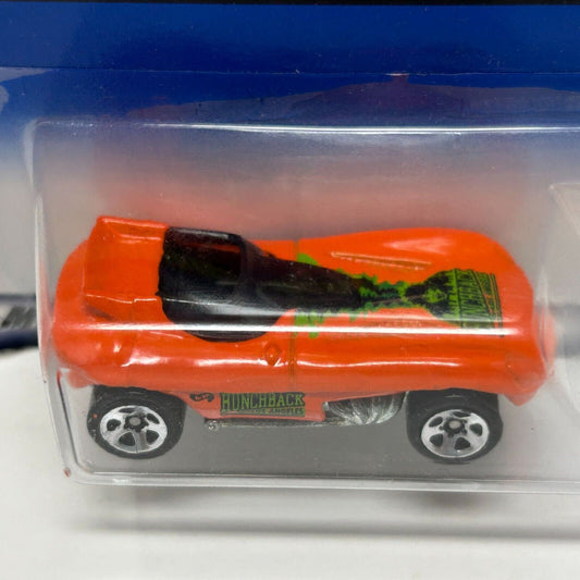 Hot Wheels orange Hunchback car in clear packaging with detailed graphics, viewed from the side