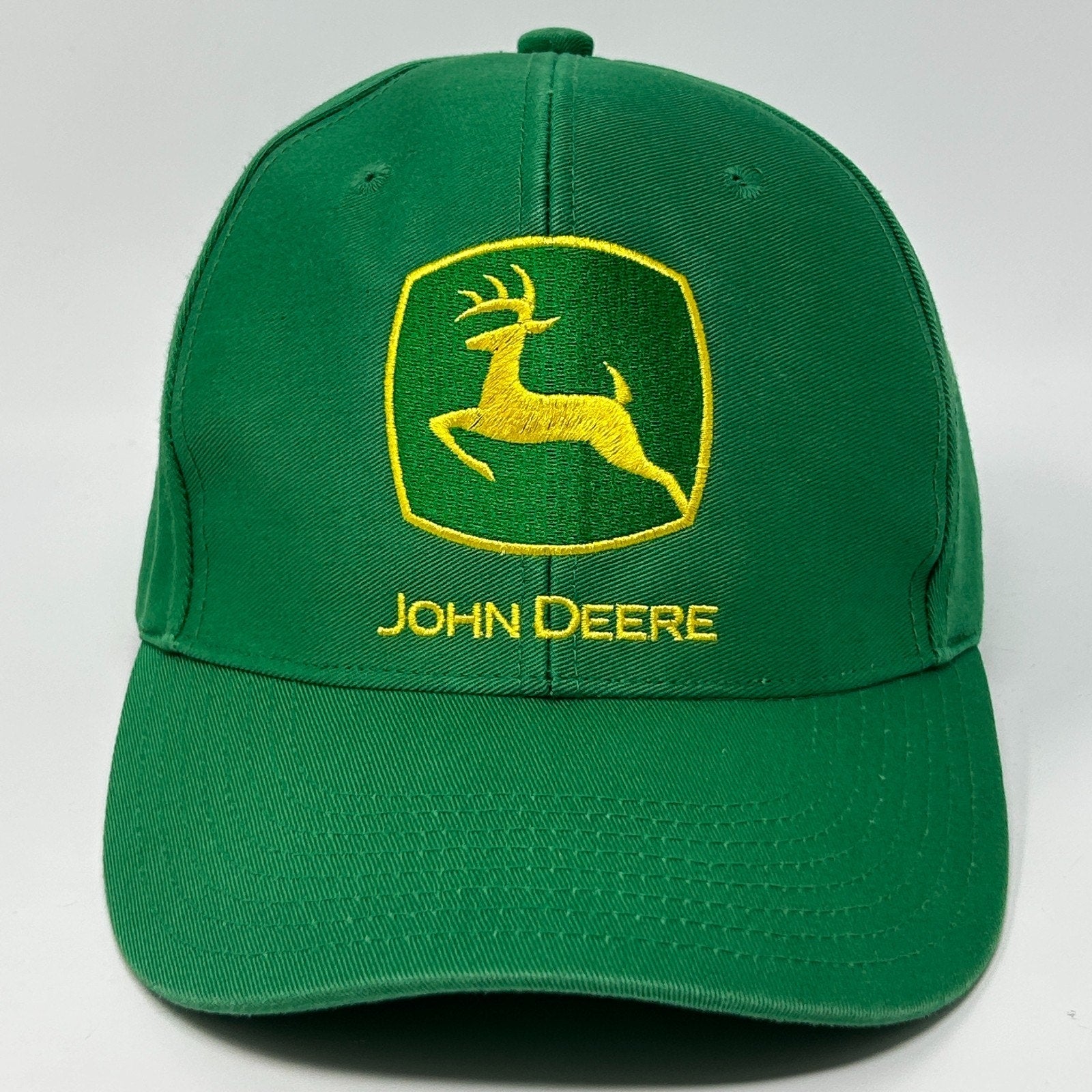 Front view of a green John Deere hat featuring the iconic logo and yellow embroidery