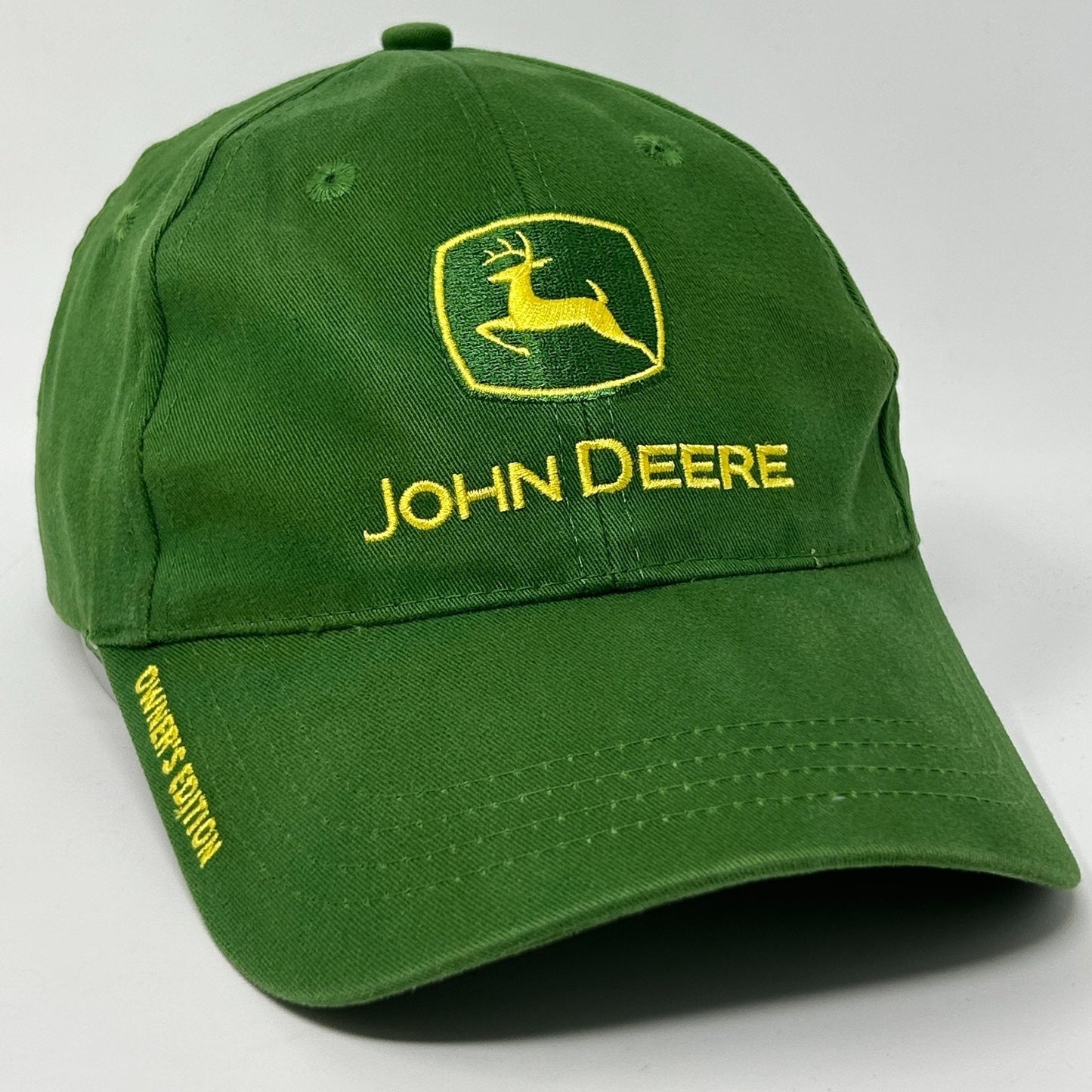 Front view of a green John Deere Hat featuring a yellow logo and embroidered 'Owner's Edition' text
