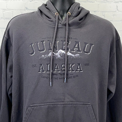 Front view of a charcoal gray hoodie featuring Juneau Alaska logo with mountains and established date