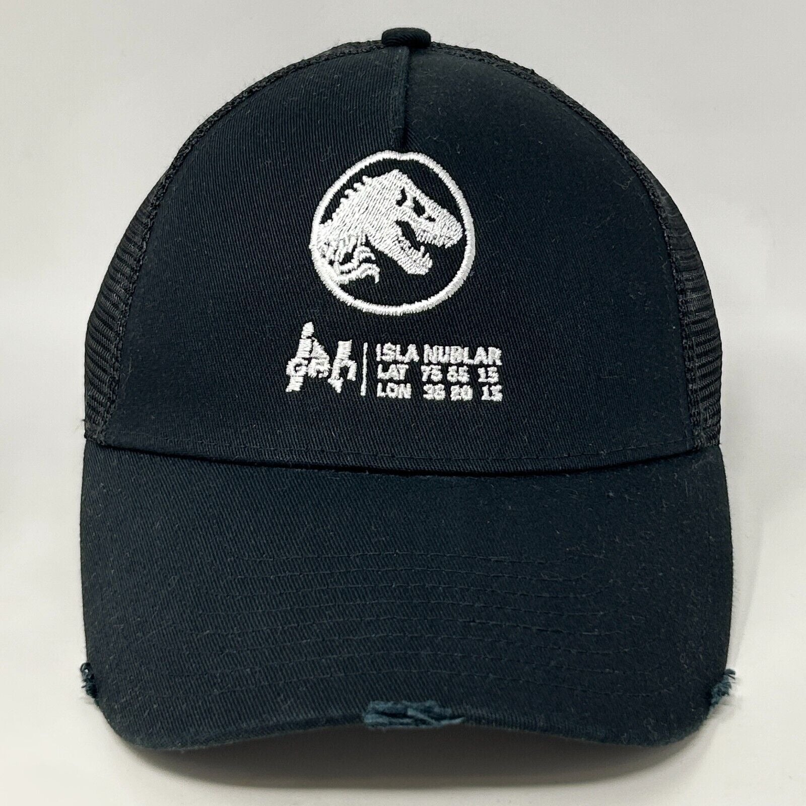 Black Jurassic Park hat featuring T-Rex logo and Isla Nublar coordinates, front view