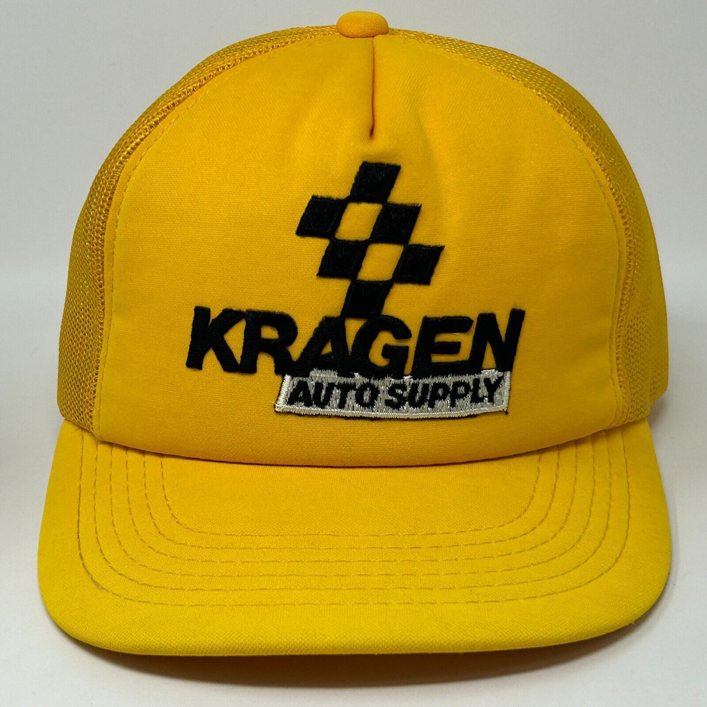 Front view of yellow trucker hat featuring Kragen Auto Supply logo in black and white