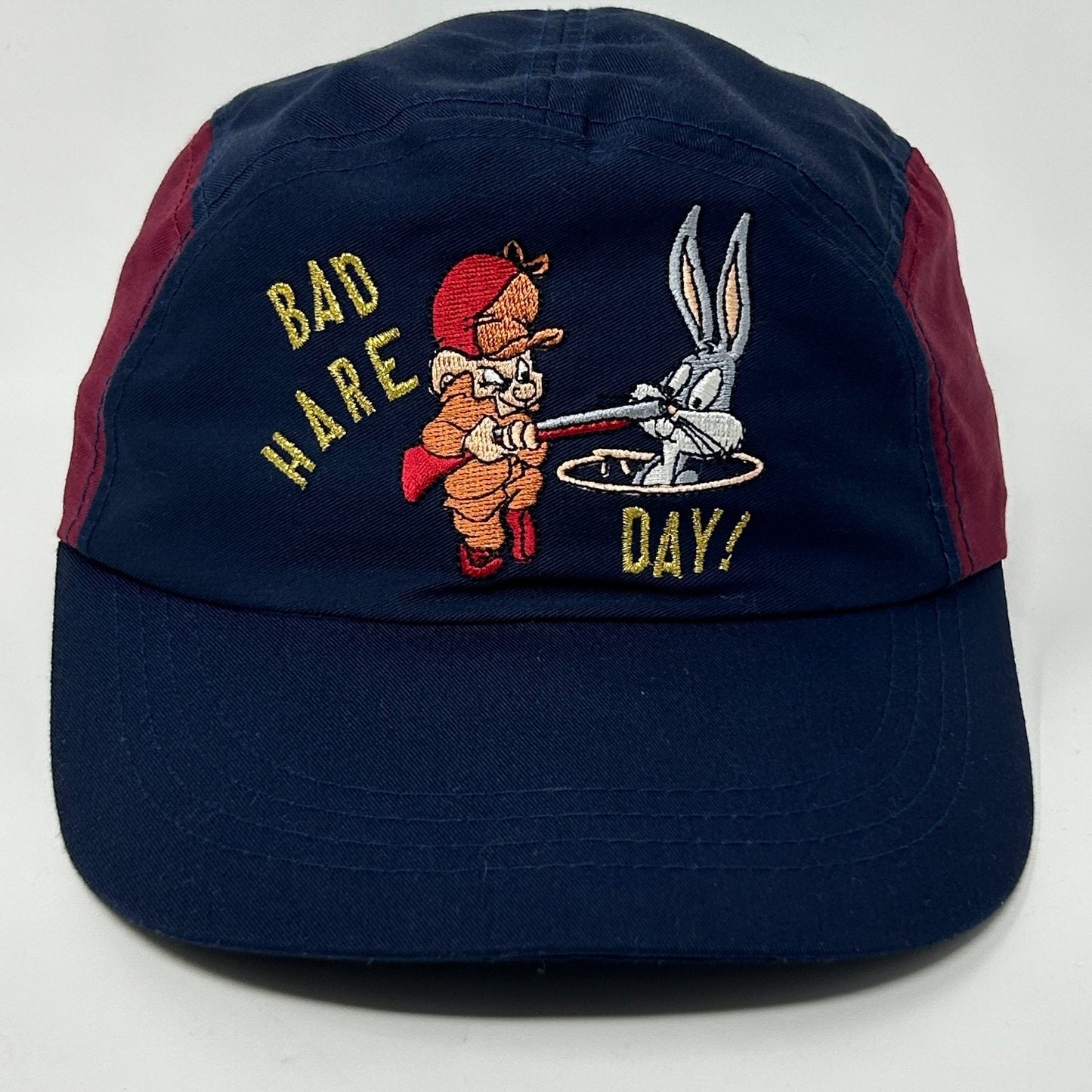 Front view of Bugs Bunny Hat in navy with embroidered design of Bugs Bunny and Elmer Fudd saying Bad Hare Day