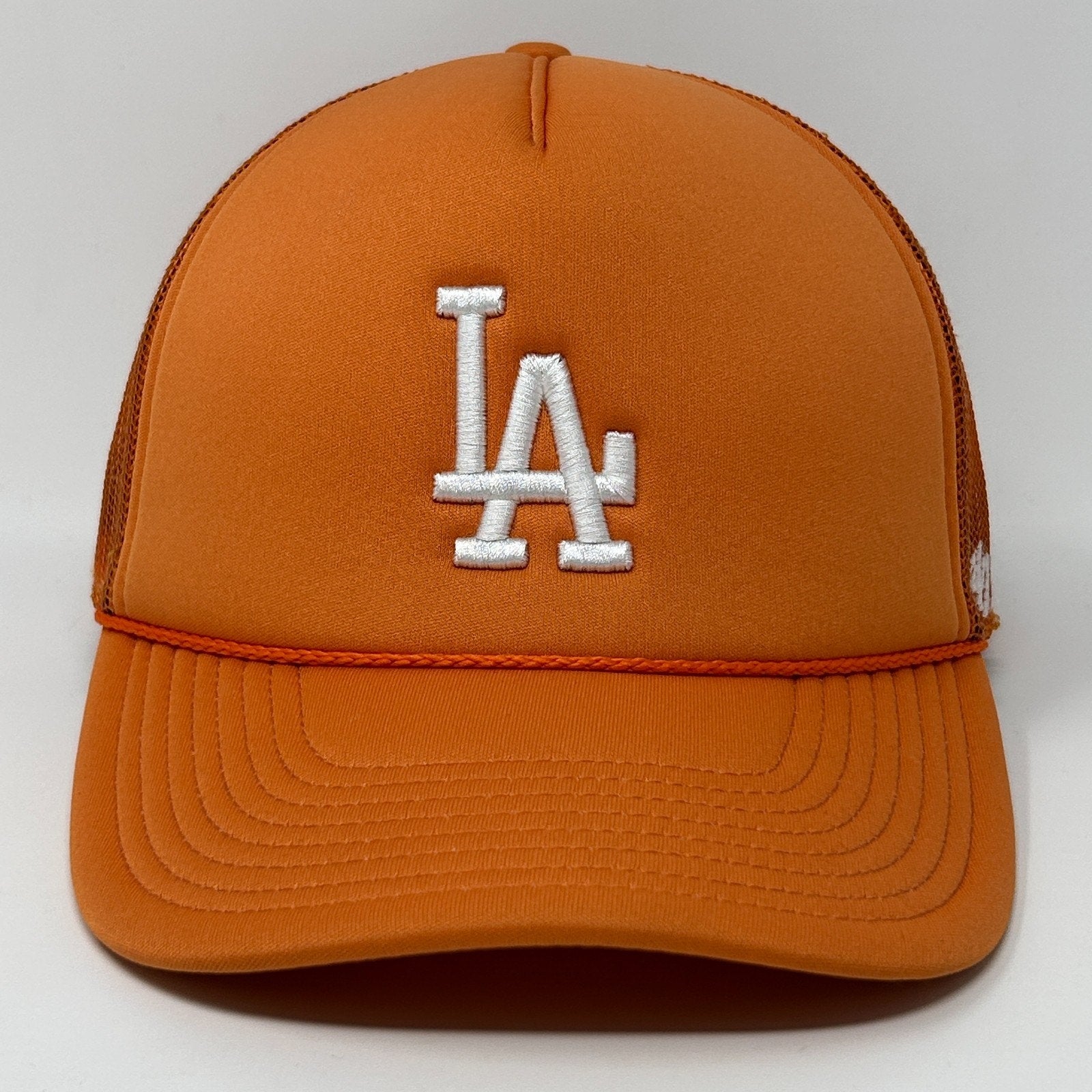 Front view of orange ’47 Los Angeles Dodgers cap with white LA logo and mesh back design