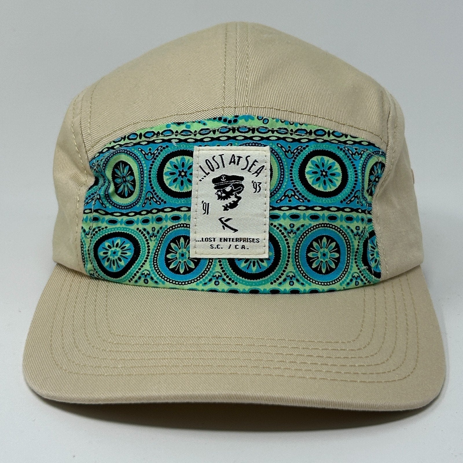 Lost Enterprises Hat in tan with patterned front panel featuring blue and green designs and logo