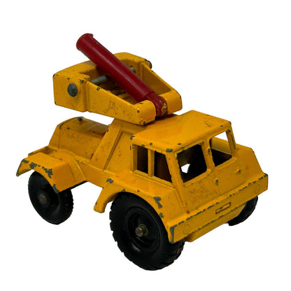 Vintage Matchbox yellow tow truck toy with red tow arm, front view, compact size, showing wear marks