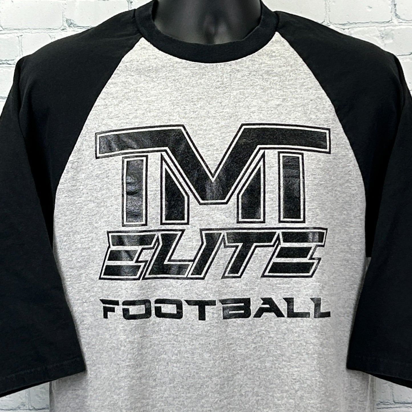 Gray and black Anvil The Money Team T Shirt with TM Elite Football logo on the front