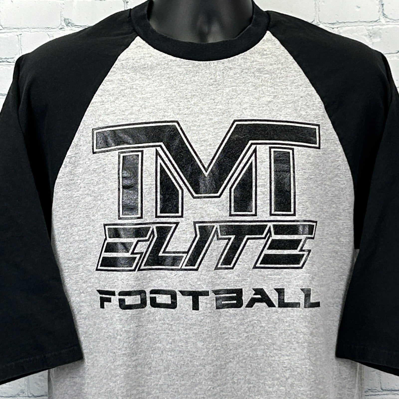 Gray and black Anvil The Money Team T Shirt with TM Elite Football logo on the front