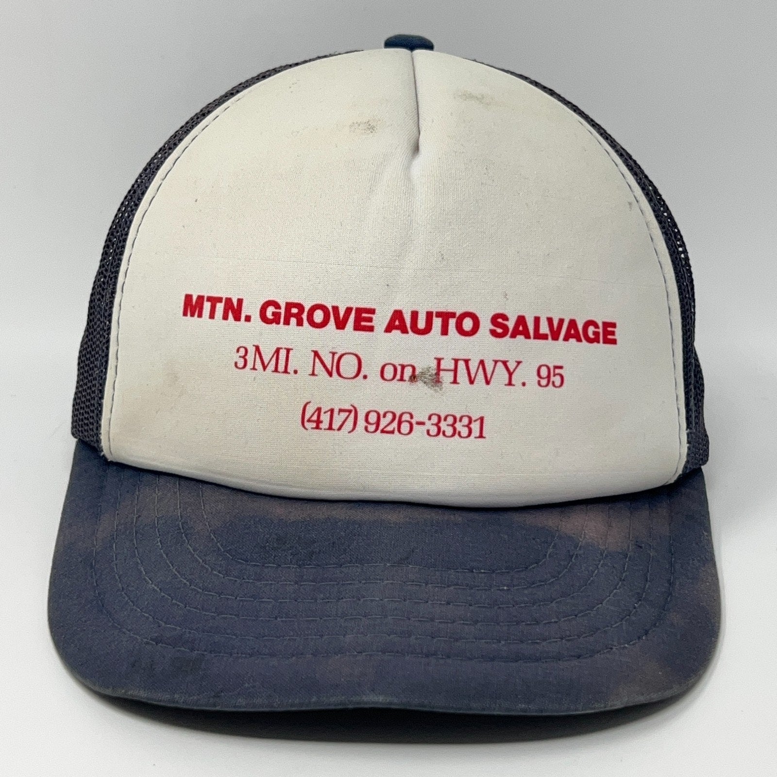 Front view of a Vintage Trucker Hat in white and navy with MTN. GROVE AUTO SALVAGE logo and contact details