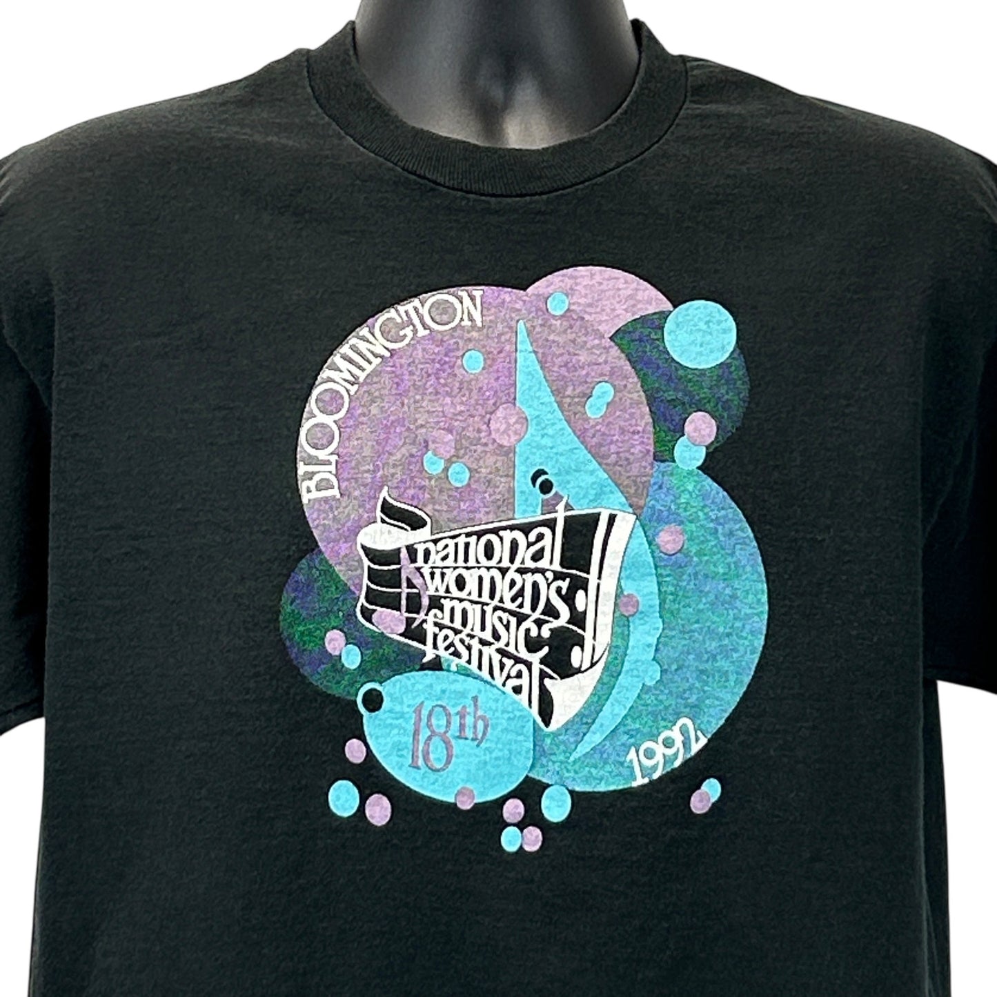 Black Fruit of the Loom T-Shirt featuring National Women's Music Festival graphic in vibrant colors