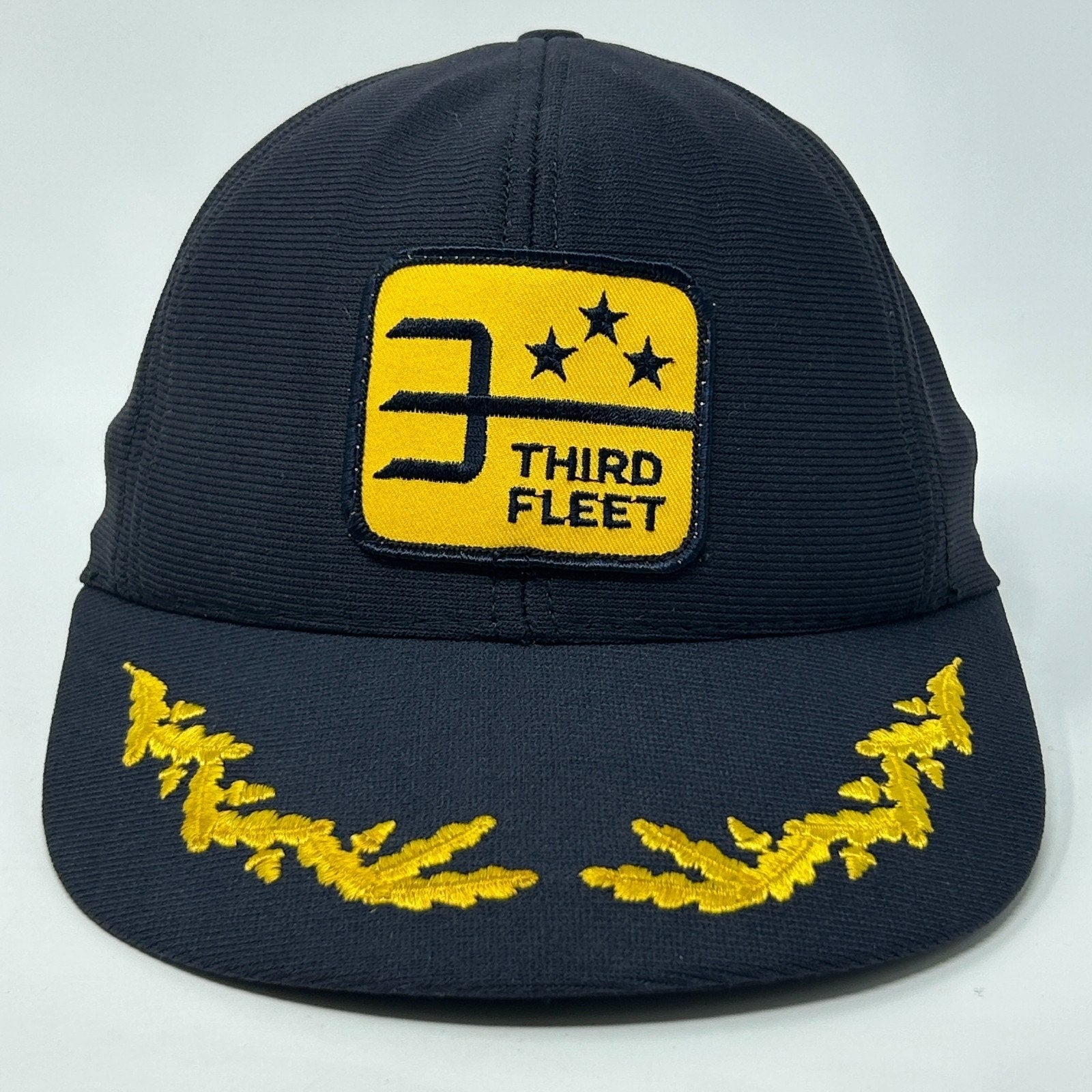 Front view of a navy blue US Navy Hat featuring a yellow Third Fleet logo and embroidered details
