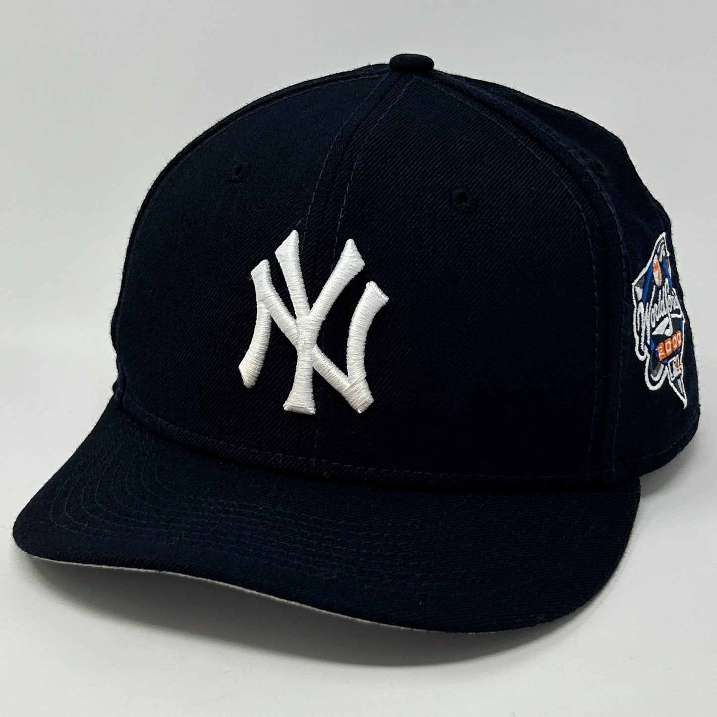 Front view of New Era Yankees hat in navy blue with white embroidered logo and side detailing