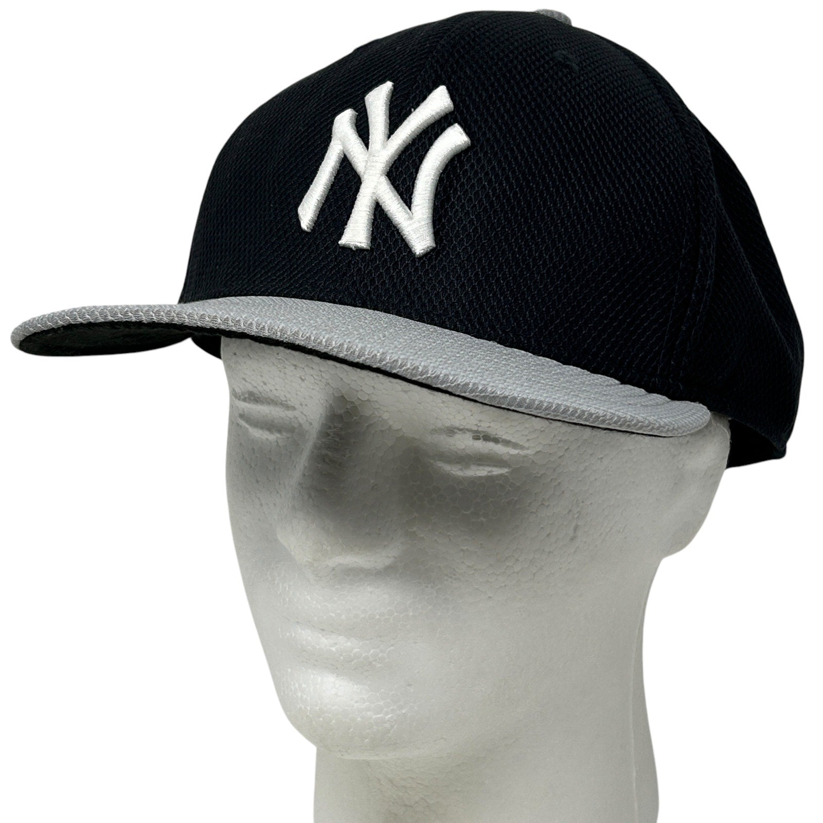 New York Yankees navy cap with white embroidered logo and grey brim, side view