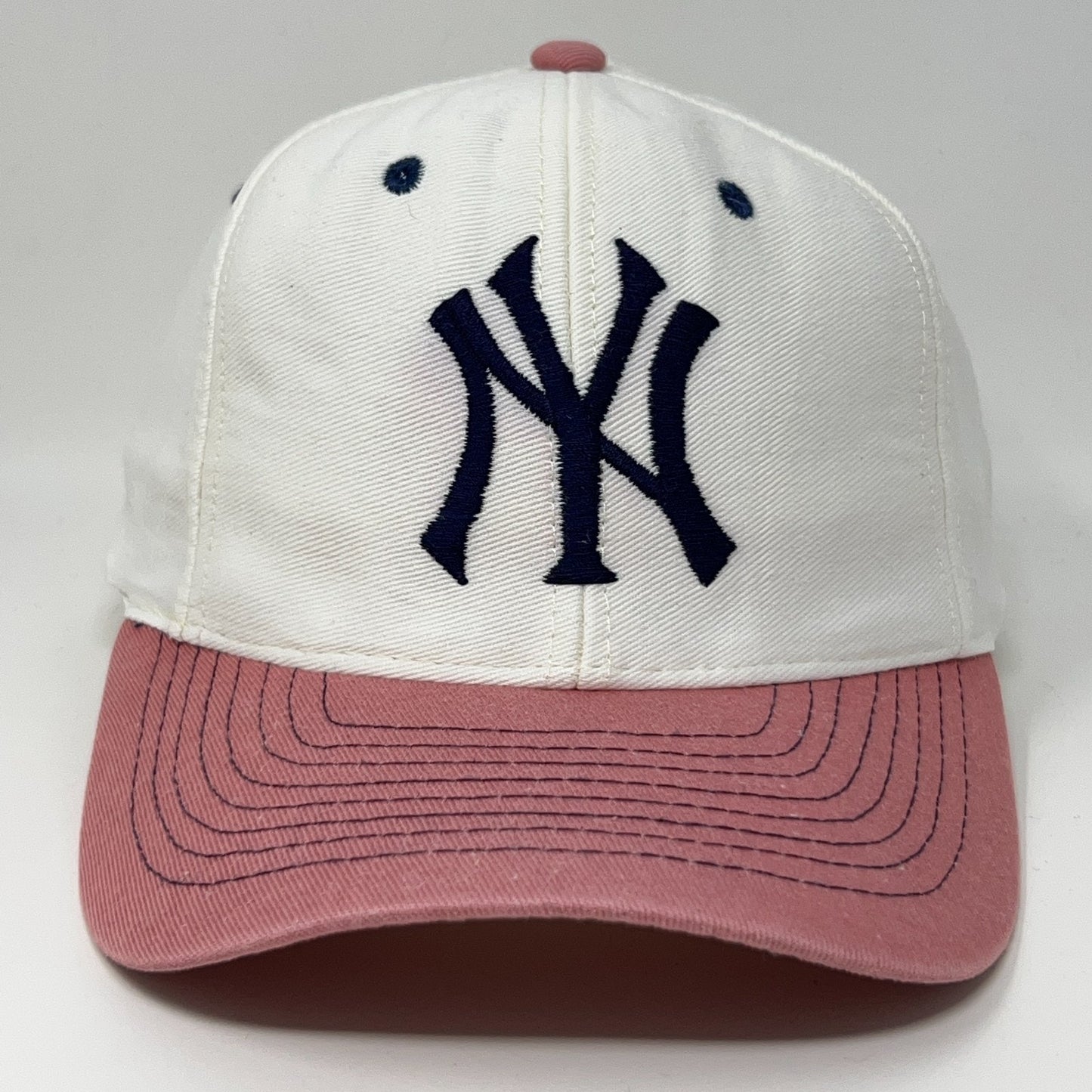 Vintage New York Yankees cap in white and pink featuring embroidered logo on the front