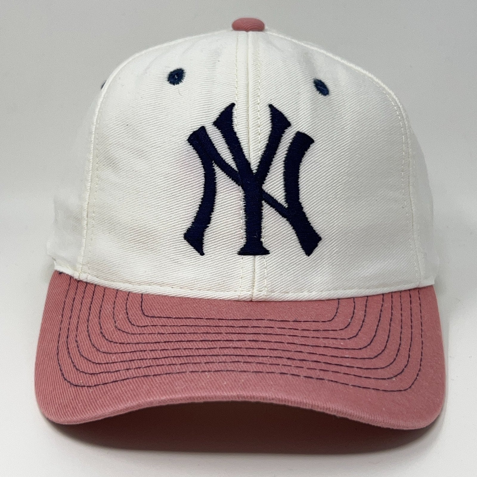 Vintage New York Yankees cap in white and pink featuring embroidered logo on the front