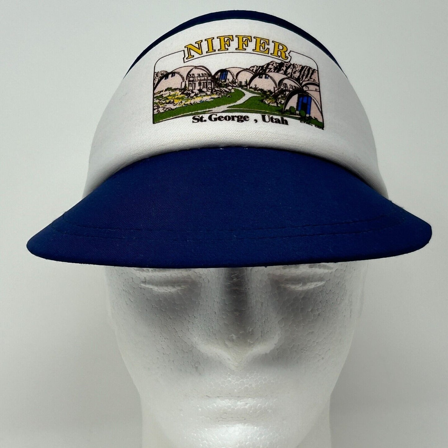 Vintage navy and white visor hat featuring St George Utah logo, showing front view with embroidered details