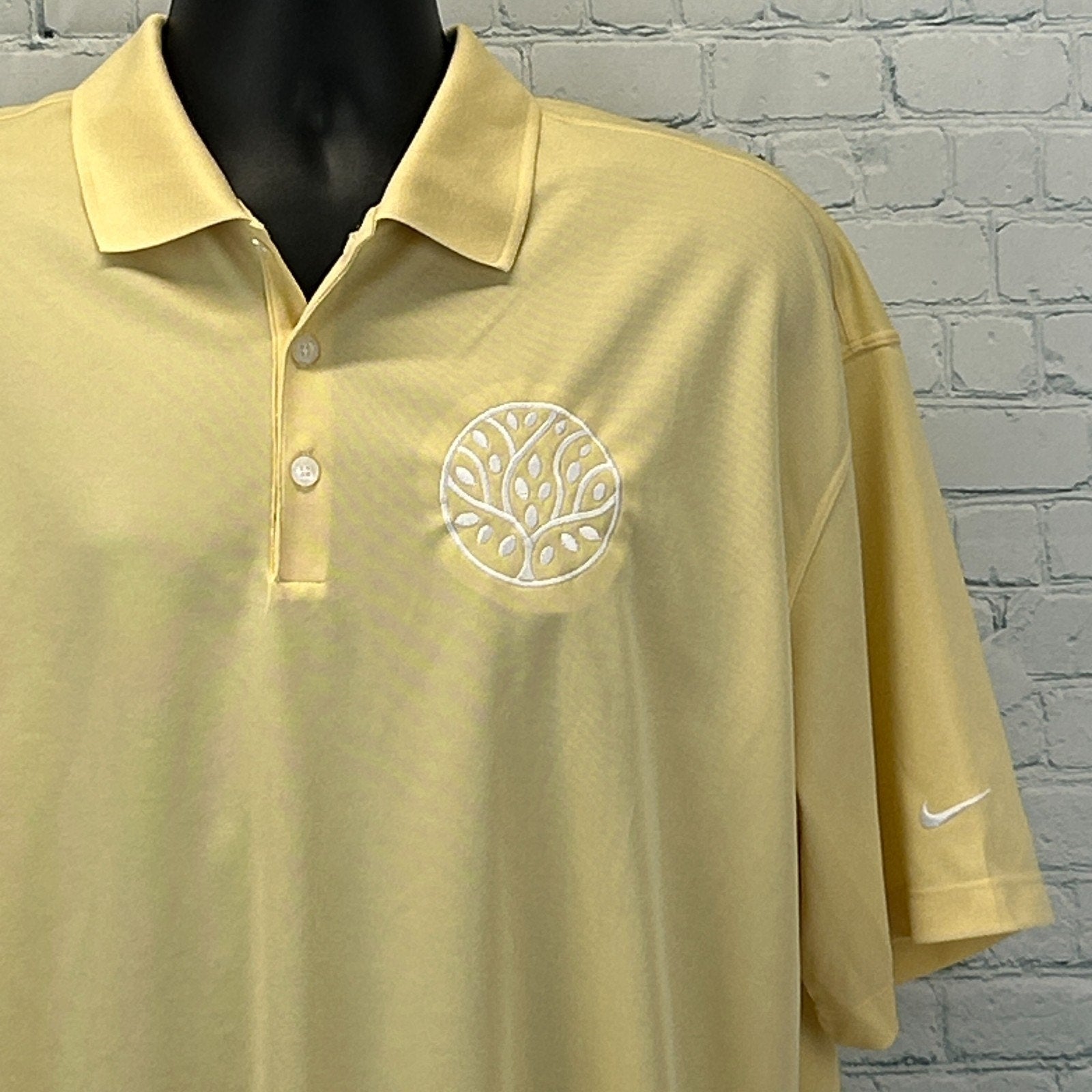 Nike Golf Polo in light yellow with embroidered tree logo on the chest, front view