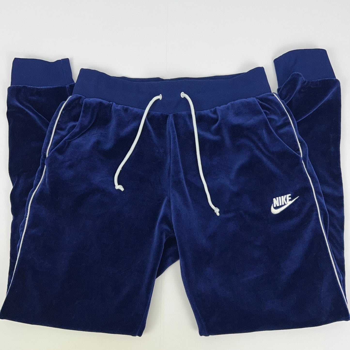 Nike navy blue velour sweatpants with white drawstrings and logo, front view