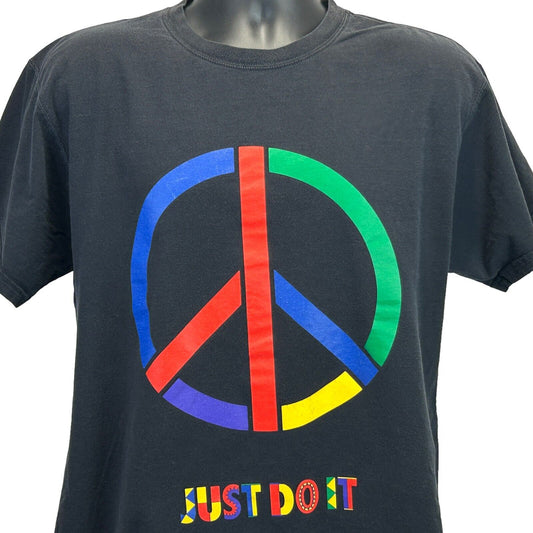 Nike T-Shirt in black featuring a colorful peace sign graphic and Just Do It logo on the front