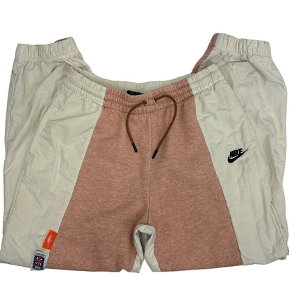 Nike sweatpants in peach and cream color, featuring adjustable drawstring and logo on the left thigh