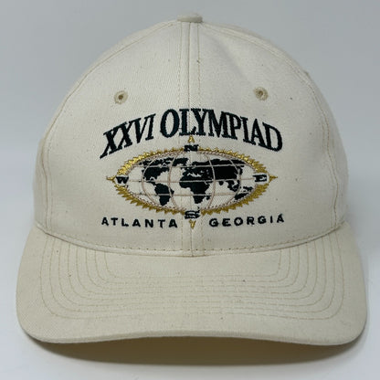 Front view of Hanes beige baseball cap featuring embroidered XXVI Olympic Games logo and world map detail.