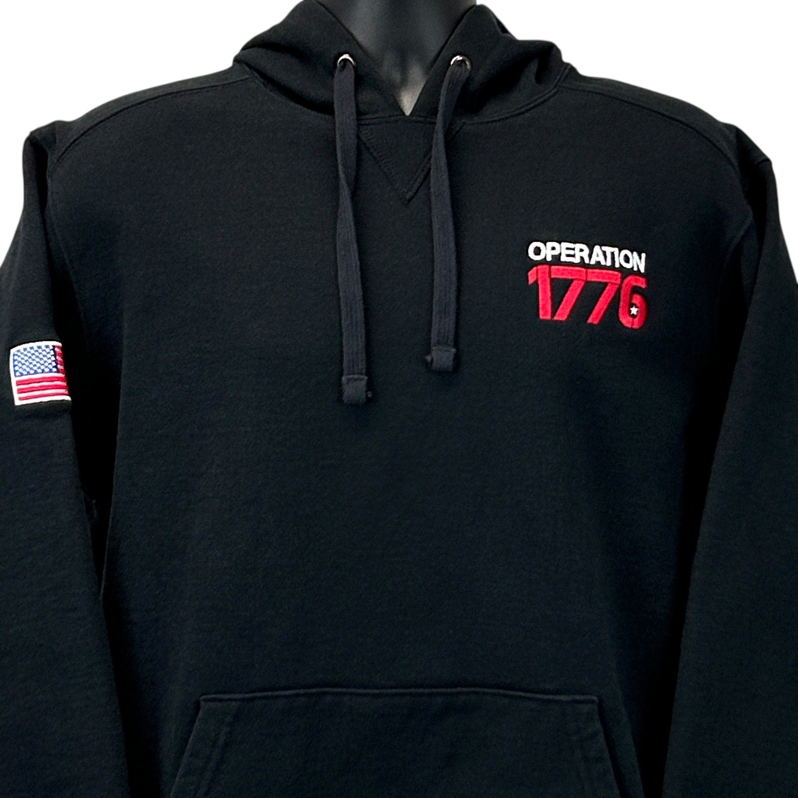 Black Volunteer Knitwear 1776 Hoodie with front view, featuring Operation 1776 logo and American flag patch