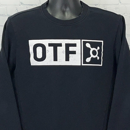 Front view of black Orangetheory long sleeve shirt featuring white OTF logo prominently displayed