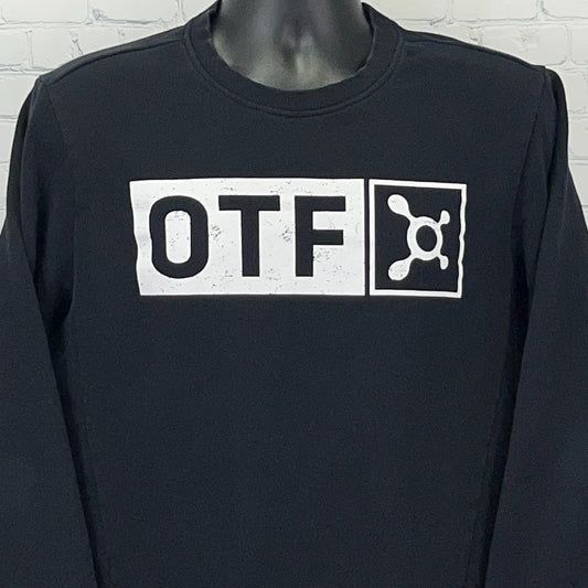 Front view of black Orangetheory long sleeve shirt featuring white OTF logo prominently displayed