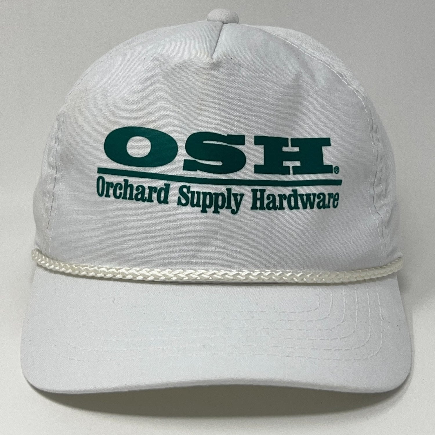 White Orchard Supply Hardware cap with OSH logo and braided detail on the brim