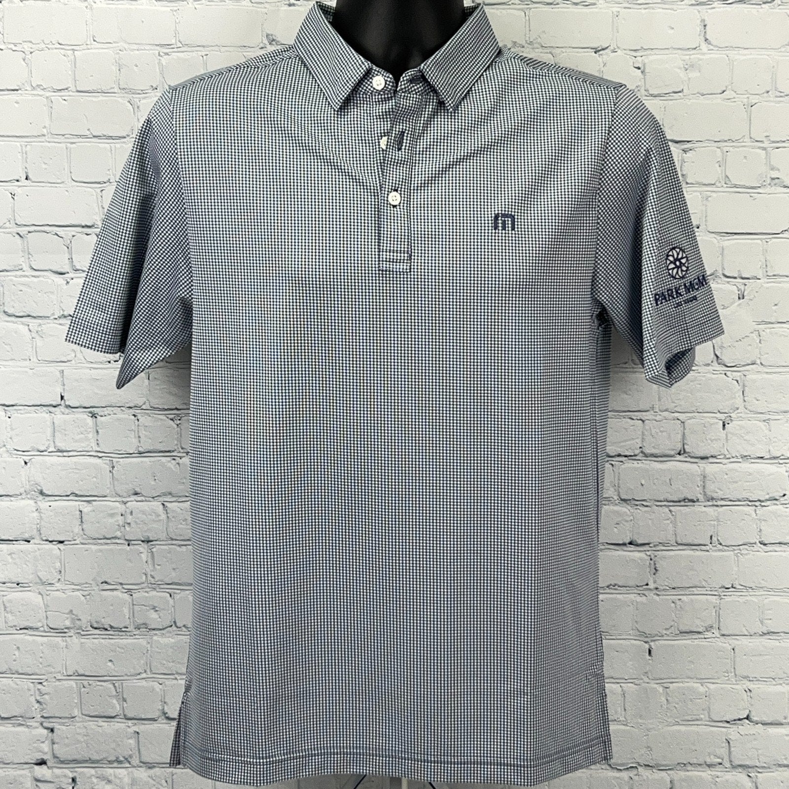 Travis Mathew golf polo shirt in navy and white check pattern, featuring Park MGM logo on sleeve