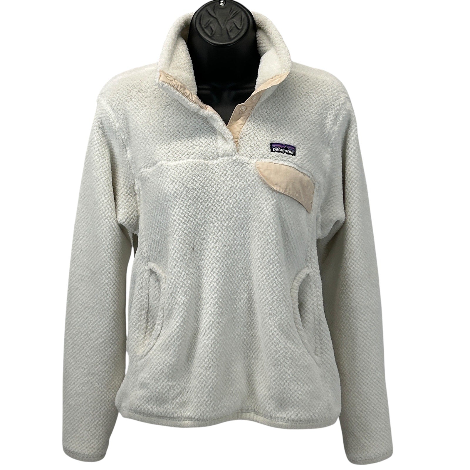 Patagonia fleece jacket in cream color with a front pocket and logo on the chest, size medium, front view