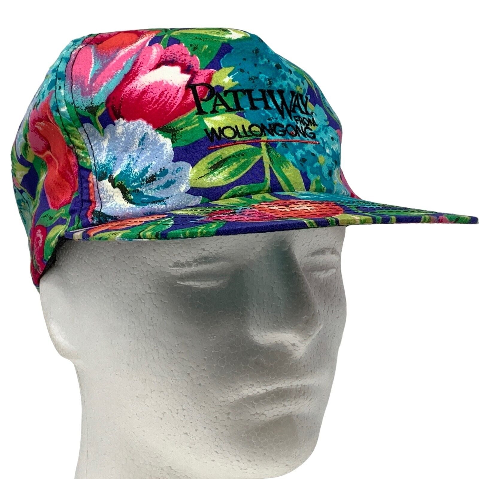 Vintage floral cap with colorful design and Pathway From Wollongong Group logo on the front