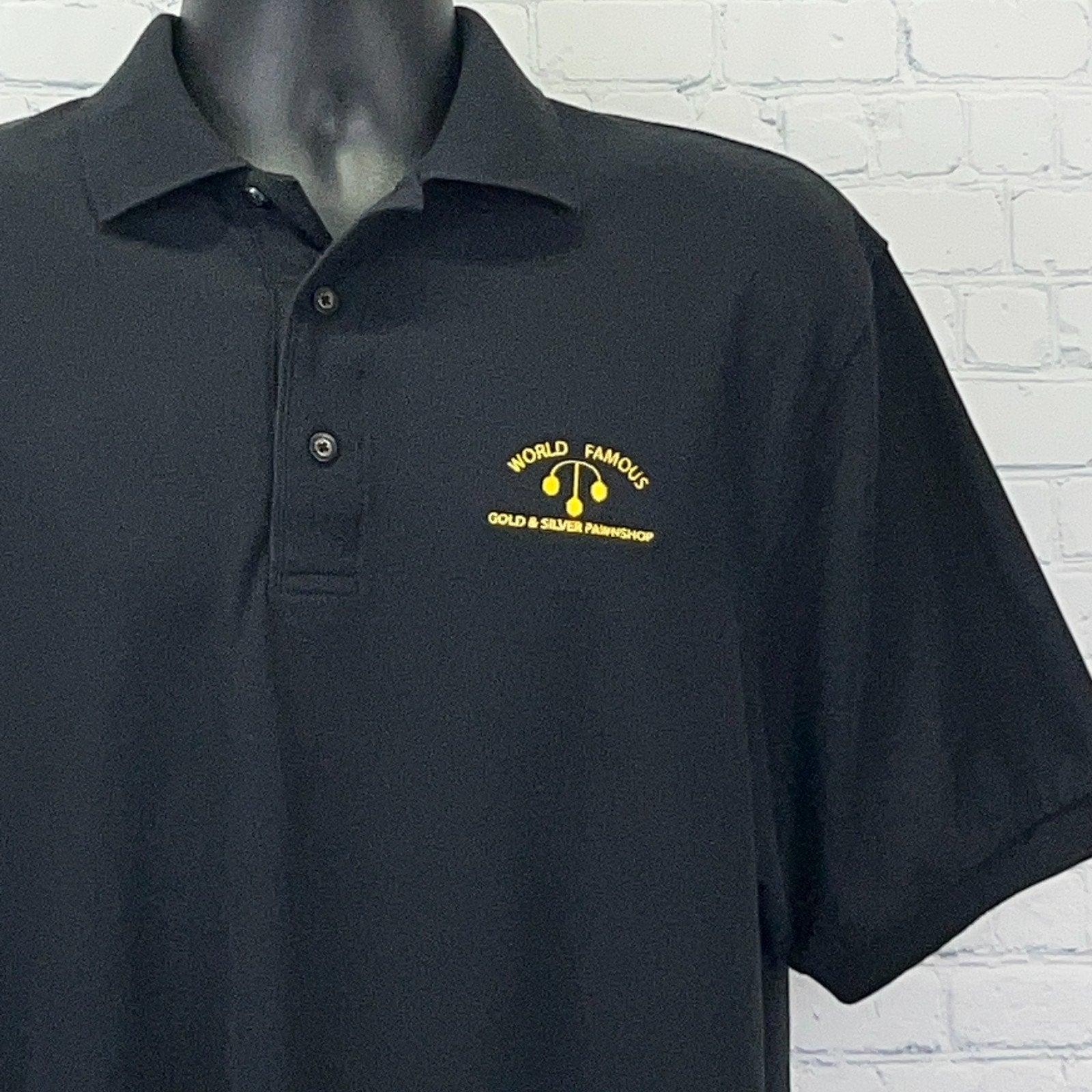 Black Port Authority Polo Shirt with Yellow 'World Famous Gold & Silver Pawnshop' Logo on Front