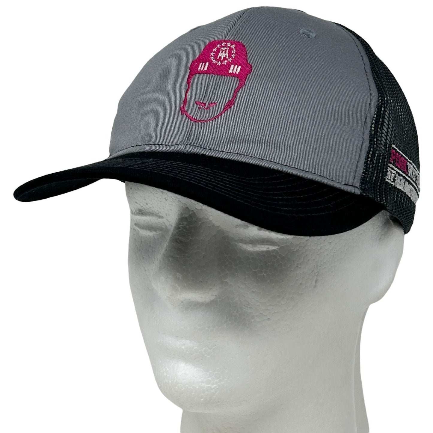 Front view of Port Authority gray and black trucker hat featuring Pink Whitney logo embroidery