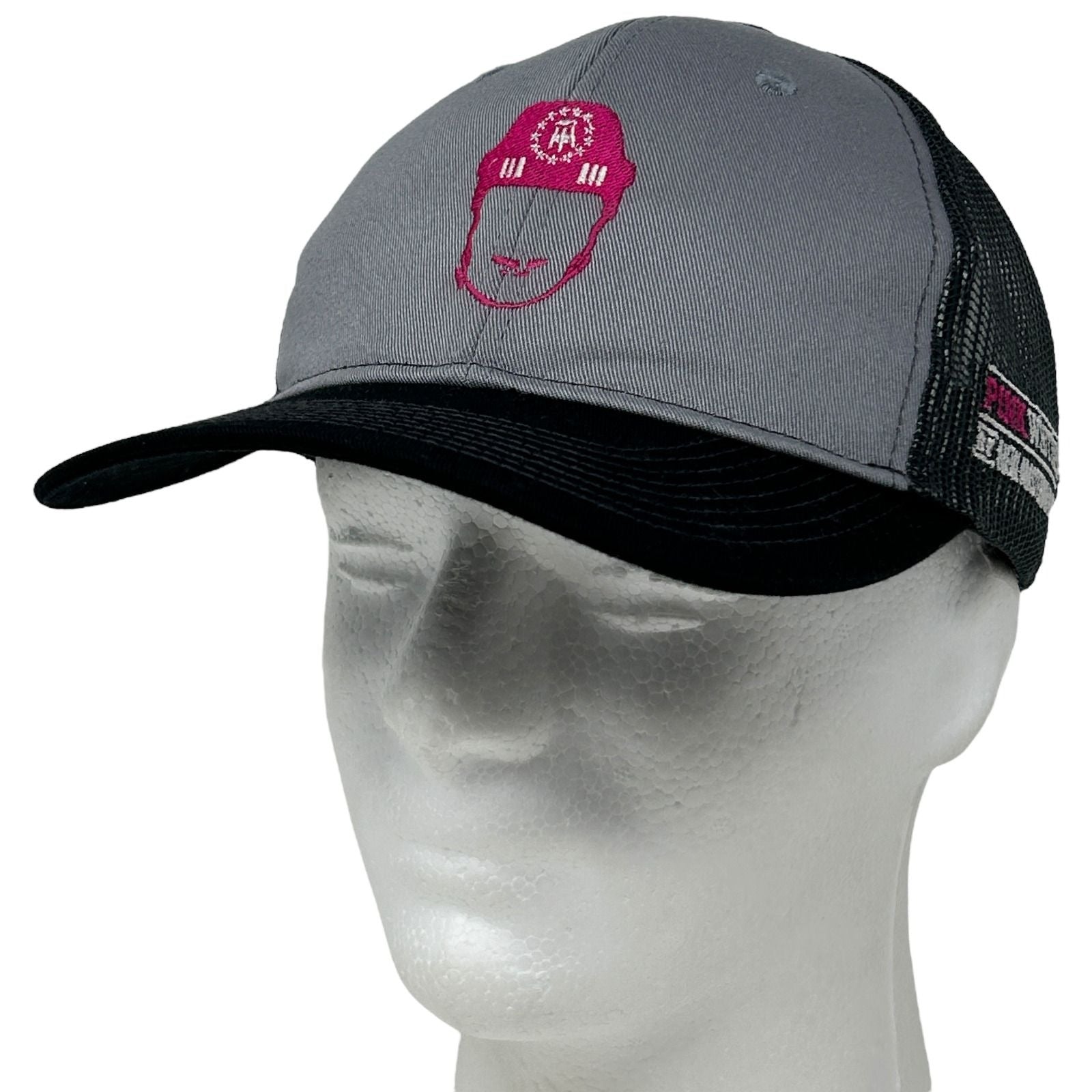 Front view of Port Authority gray and black trucker hat featuring Pink Whitney logo embroidery