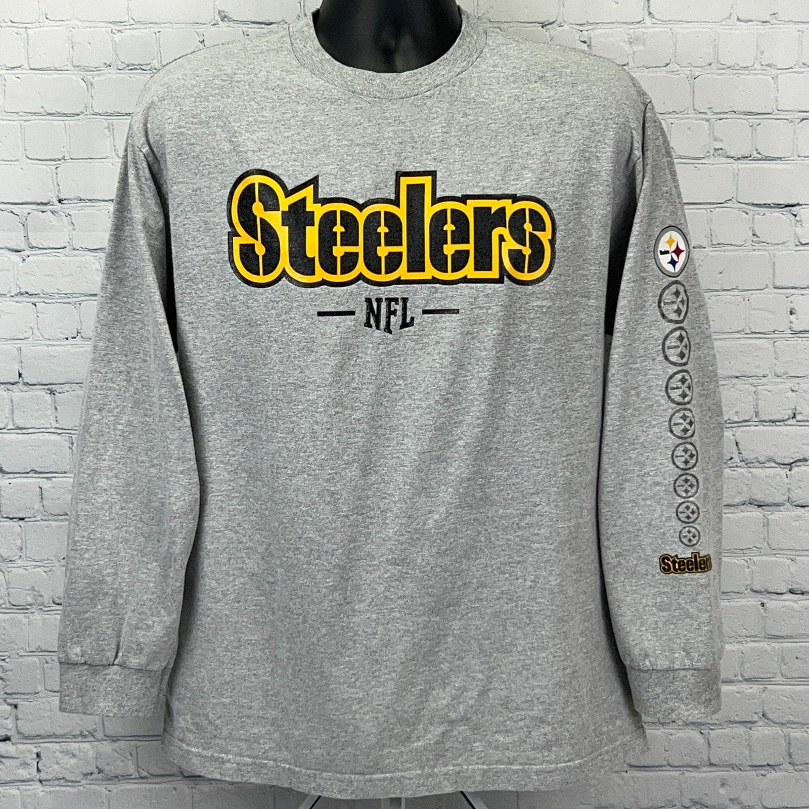 Gray long-sleeve Pittsburgh Steelers shirt featuring bold logo and NFL branding on the front
