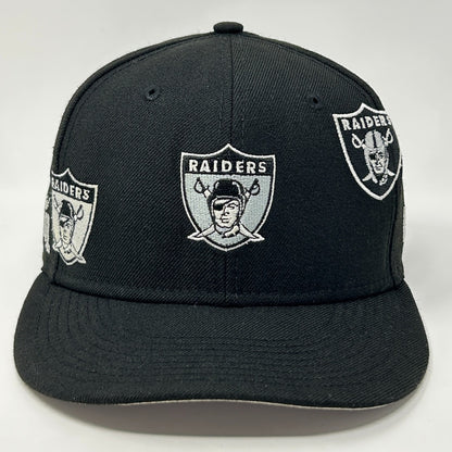 Black New Era Raiders Hat featuring multiple embroidered team logos on the front view.