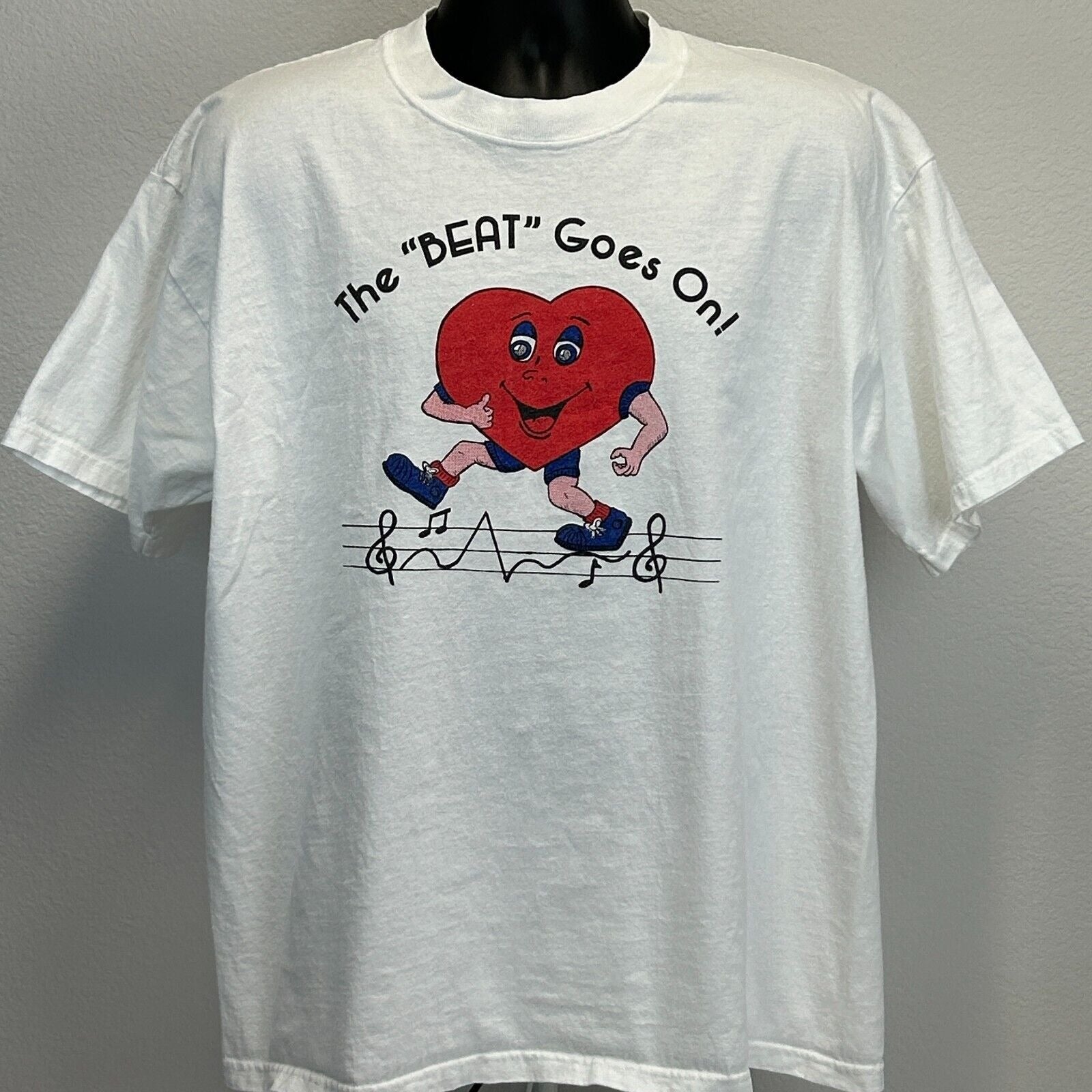 White Gildan T-Shirt with Riverview Cardiac logo featuring a cartoon heart running and musical notes