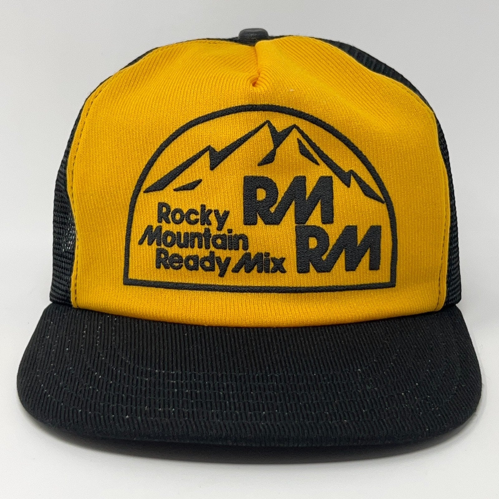 Vintage Trucker Hat in yellow and black featuring Rocky Mountain Ready Mix logo on the front