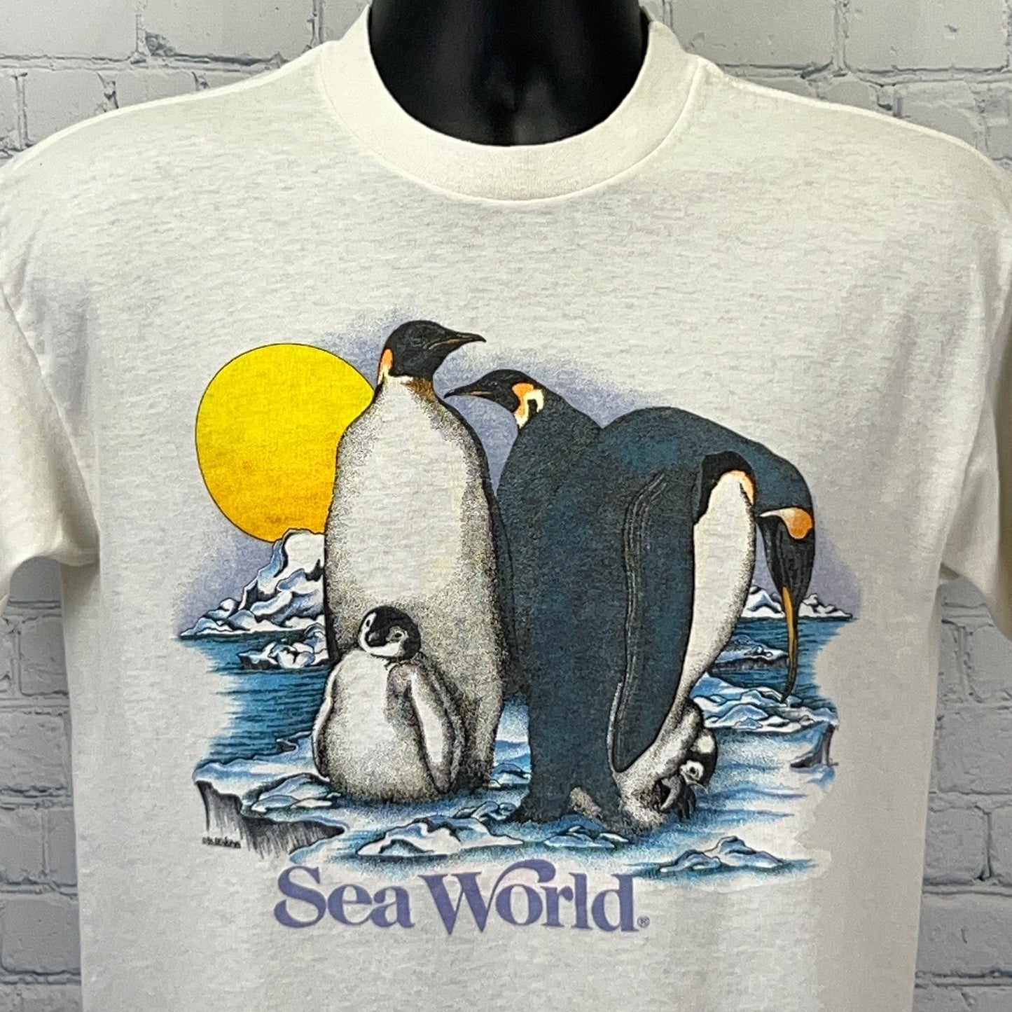 Vintage SeaWorld Penguins T-shirt in cream color featuring colorful penguin graphic with sun and icebergs