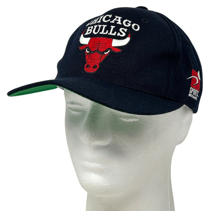 Front view of a black Chicago Bulls hat with embroidered logo and green brim