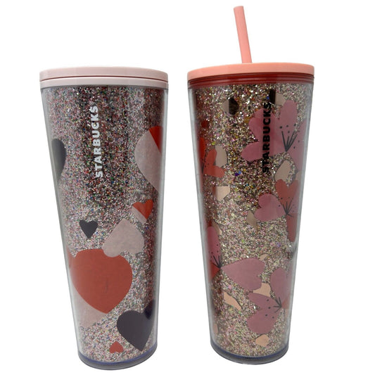 Starbucks reusable tumbler with glitter design, featuring hearts and flowers in shades of pink and red, front view