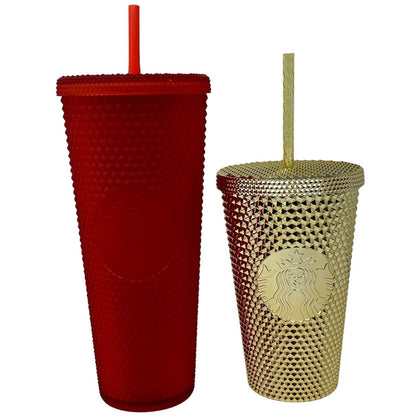 Starbucks tumblers in red and gold with textured designs and reusable straws, showcasing front views