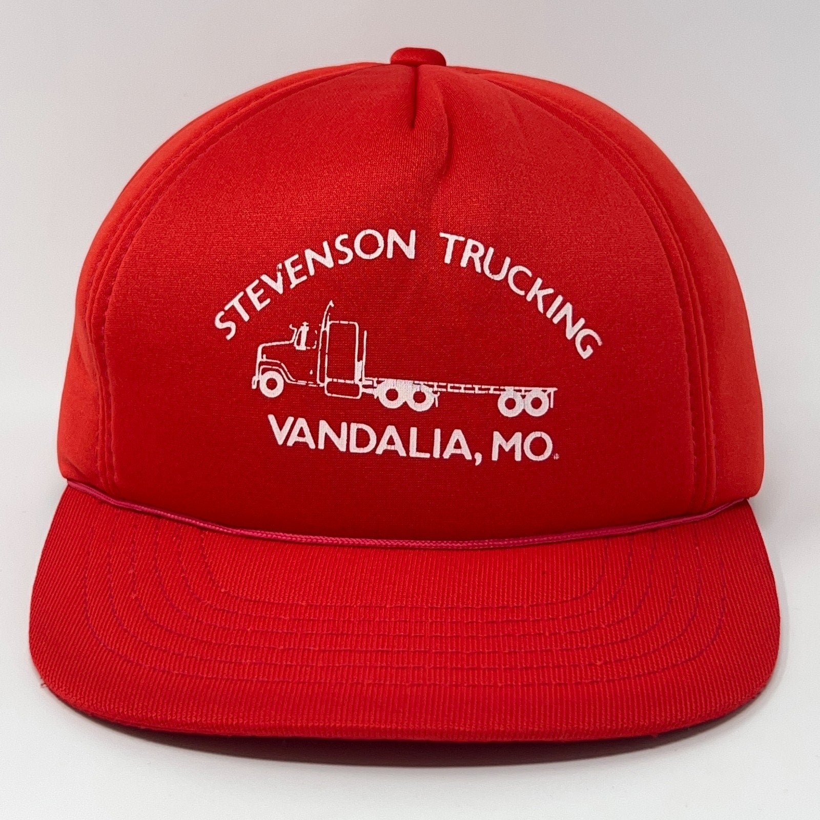 Front view of red Trucker Hat with Stevenson Trucking logo from Vandalia, MO