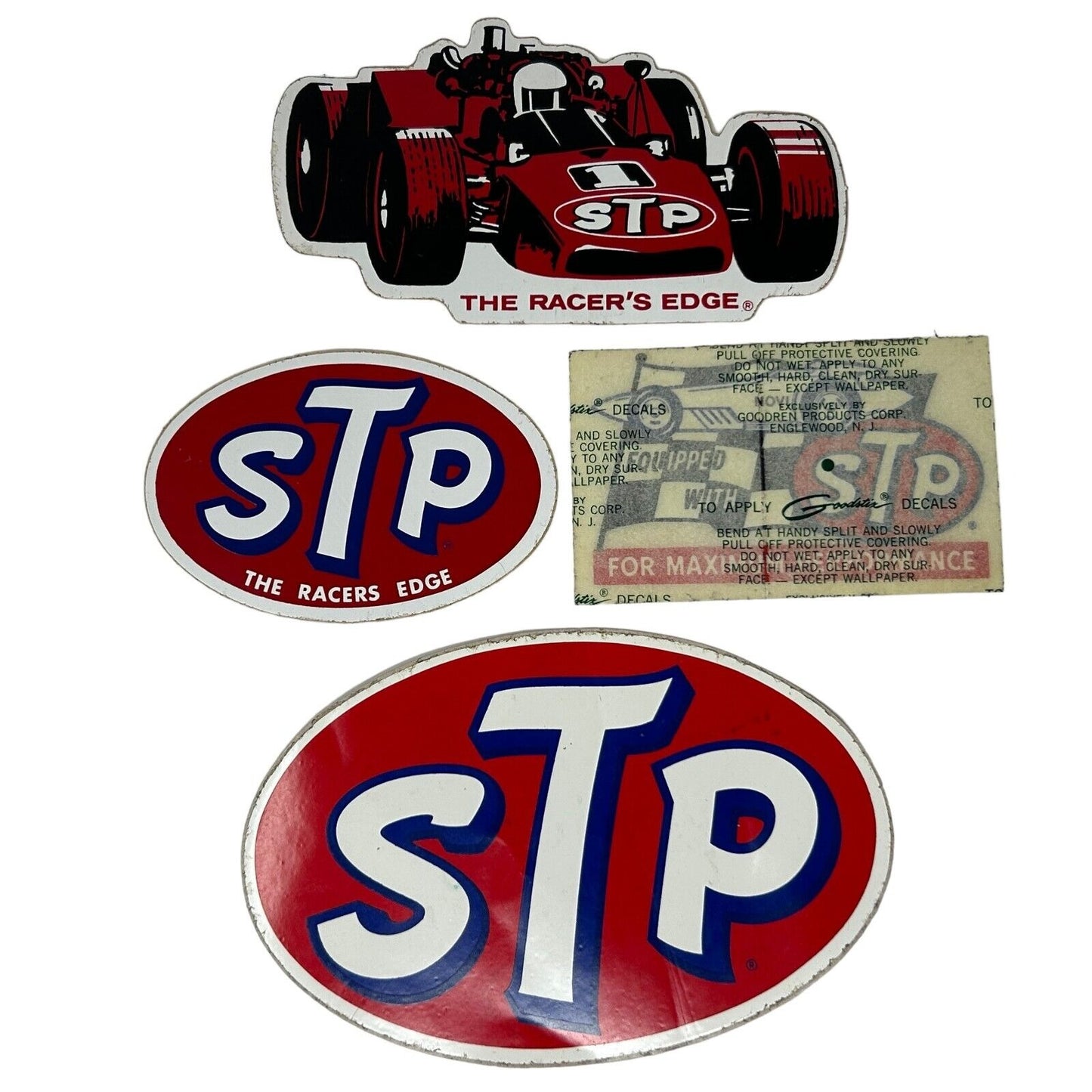 Vintage STP sticker set featuring a red race car and oval logo in various sizes for collectors